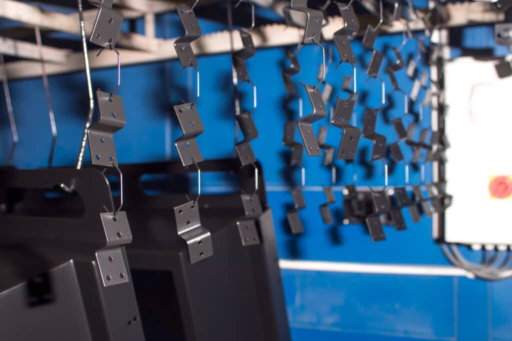 spare parts are hanging for painting. powder painting. stainless steel. metal working.